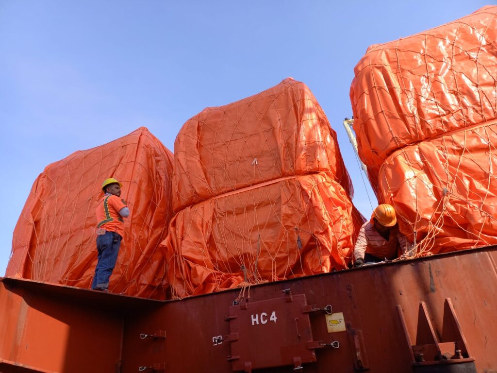 Algunos de los 33 camiones de la carga de gran escala break bulk de xpd global sobre el buque, cubiertos por lonas. Some of the 33 trucks large-scale cargo break bulk over the ship, covered in plastic.