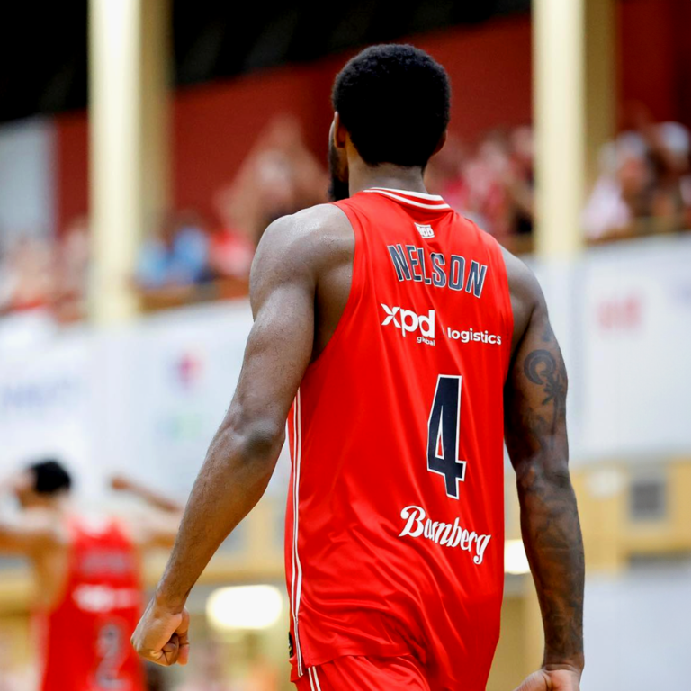 An image of Nelson, one of Bamberg Basketball stars, with the red shirt with the xpd global logo.